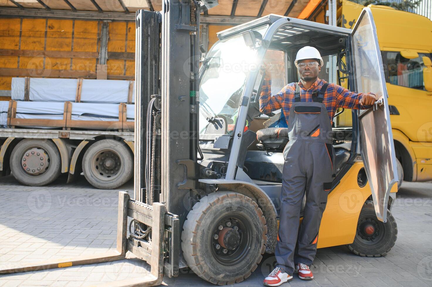 africano logística hombre como un máquina elevadora conductor en el almacén de un carga promotor foto