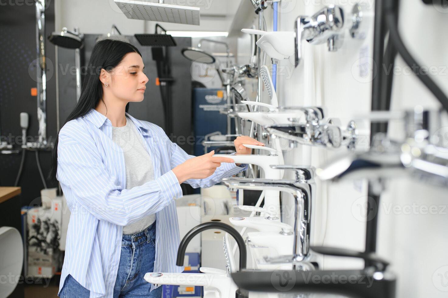 Woman choosing a shower head in a hardware store photo