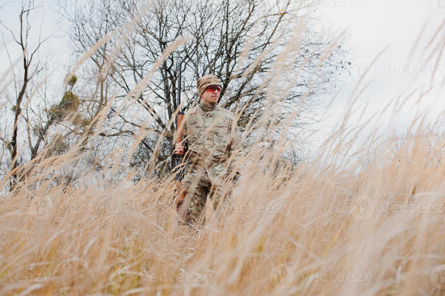 Hunter in uniform with a hunting rifle. Hunting Concept. photo