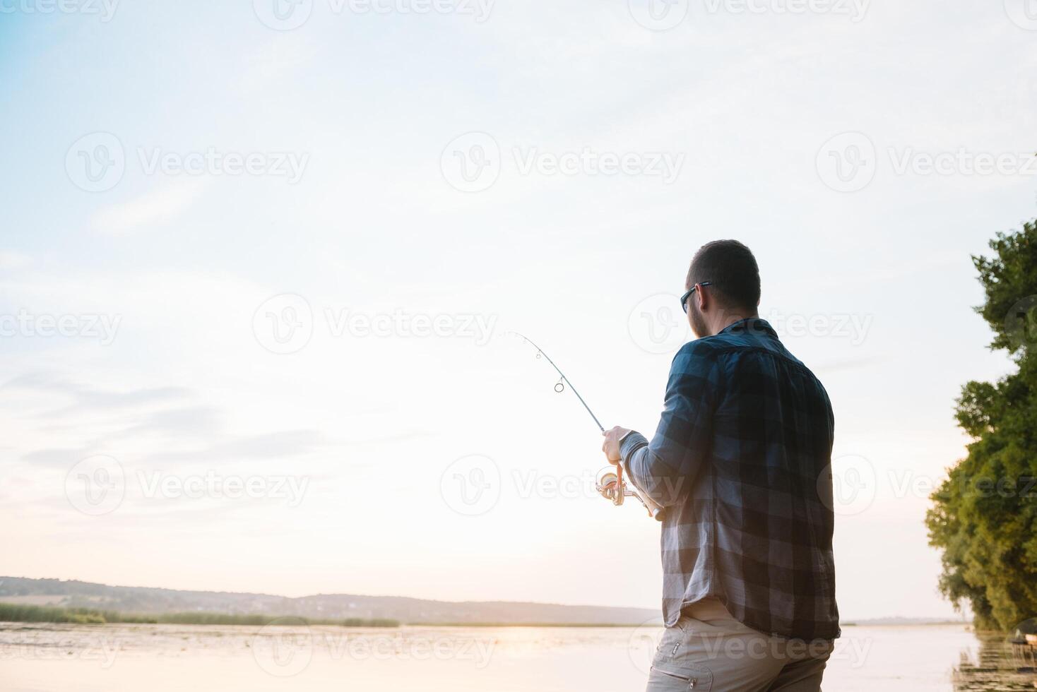 Fishing. spinning at sunset. Silhouette of a fisherman. photo