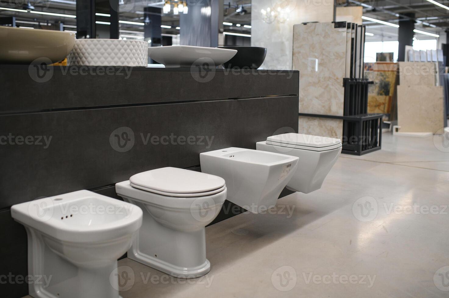Ceramic toilet bowls of various shapes and sizes in the trading floor of a specialised store photo