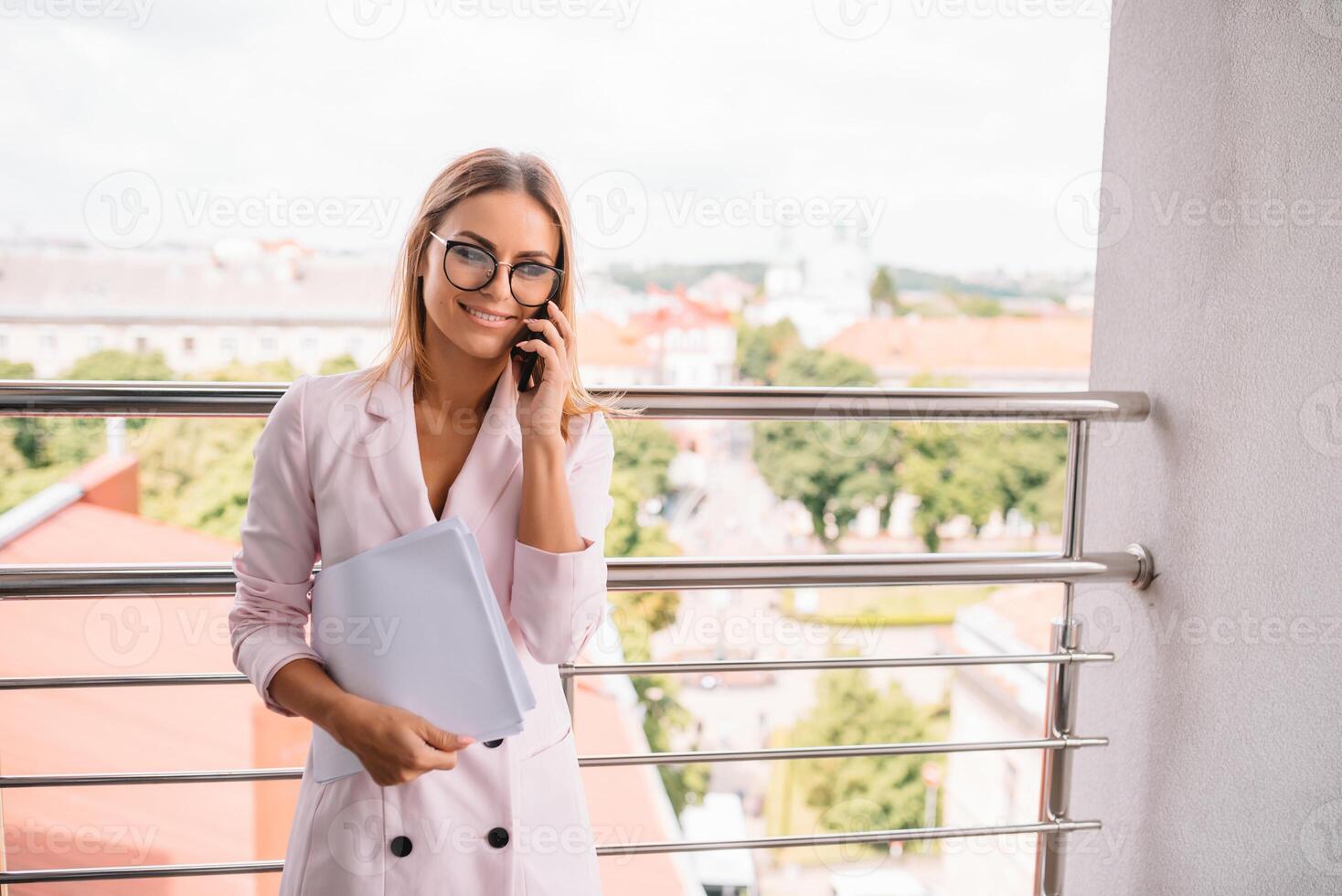Portrait of a charming business woman chatting on her smart phone while waiting someone in cafe outdoors, gorgeous female using mobile phone while sitting in cozy restaurant in the fresh air during. photo