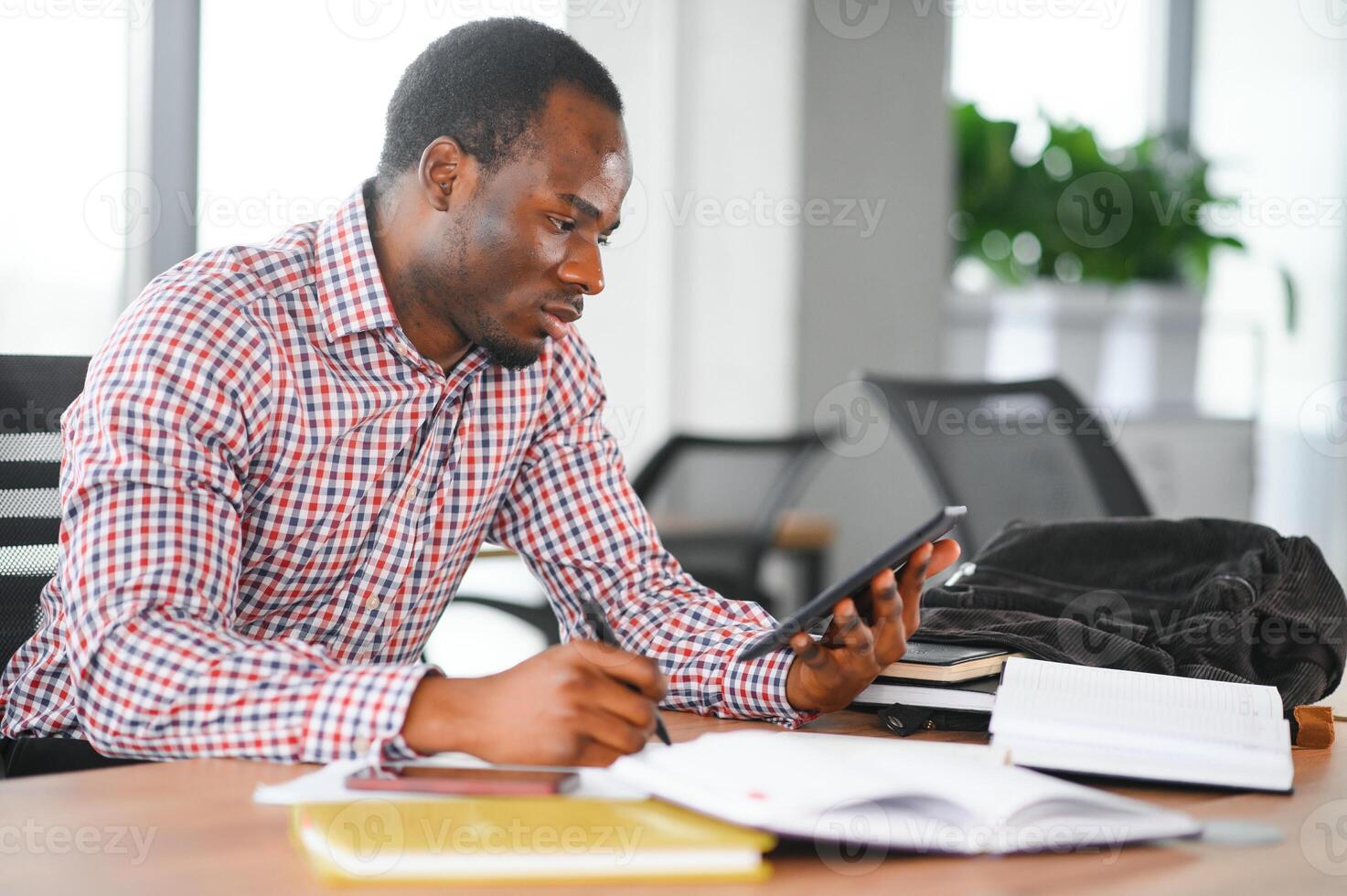 African student sitting in classroom. Male student during the lecture in high school classroom photo