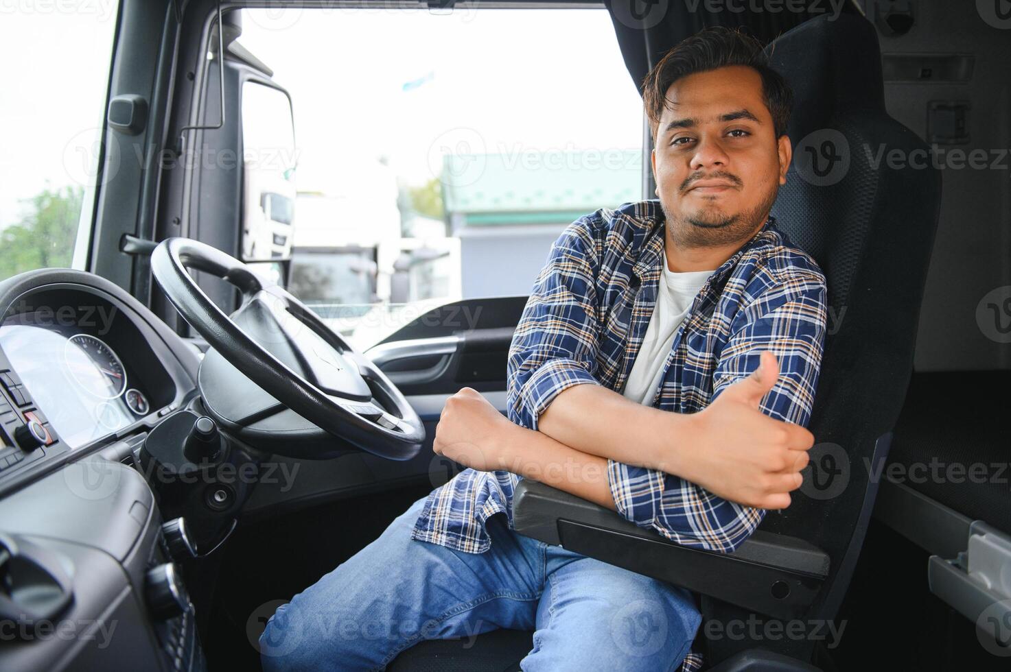 Portrait of a young handsome Indian truck driver. The concept of logistics and freight transportation. photo