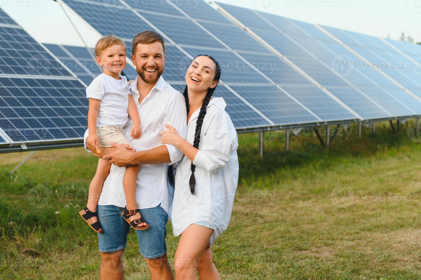 The concept of green energy. Happy family walking and having fun in solar panel field. Green energy. photo
