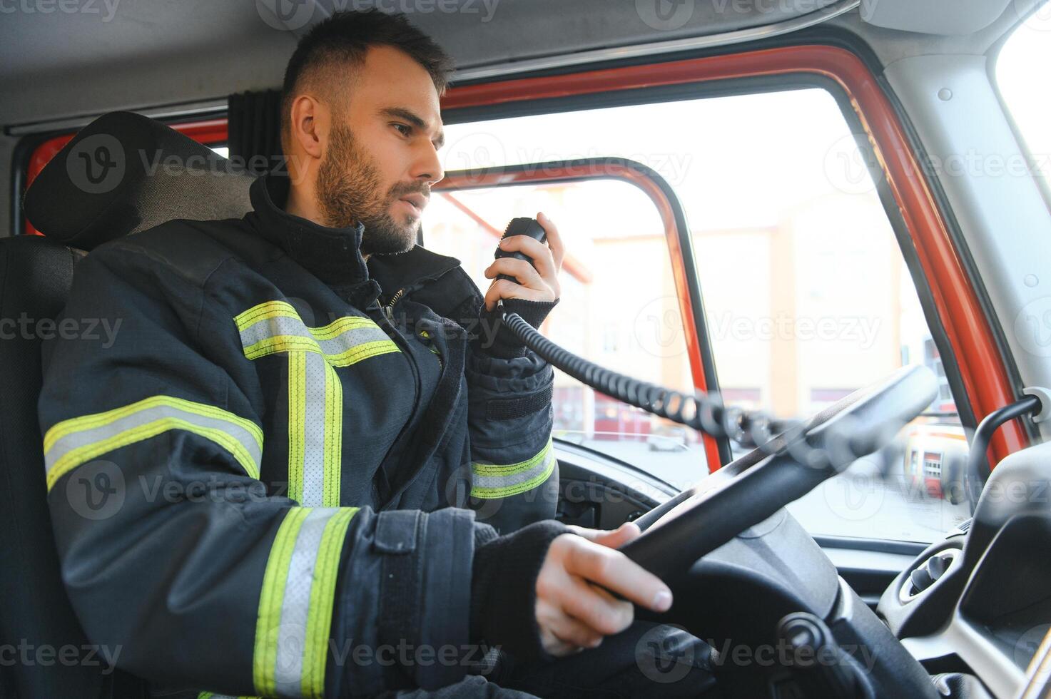 bombero utilizando radio conjunto mientras conducción fuego camión foto