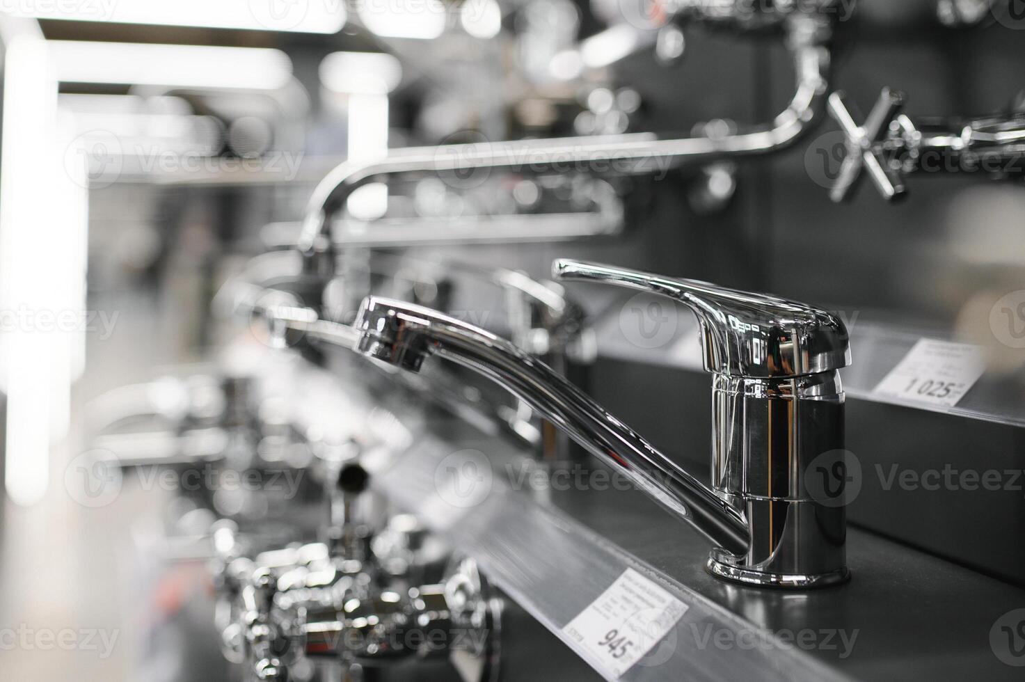 Water taps of different types and shapes on the counter in the store. Retail trade in sanitary ware. Foreground. photo