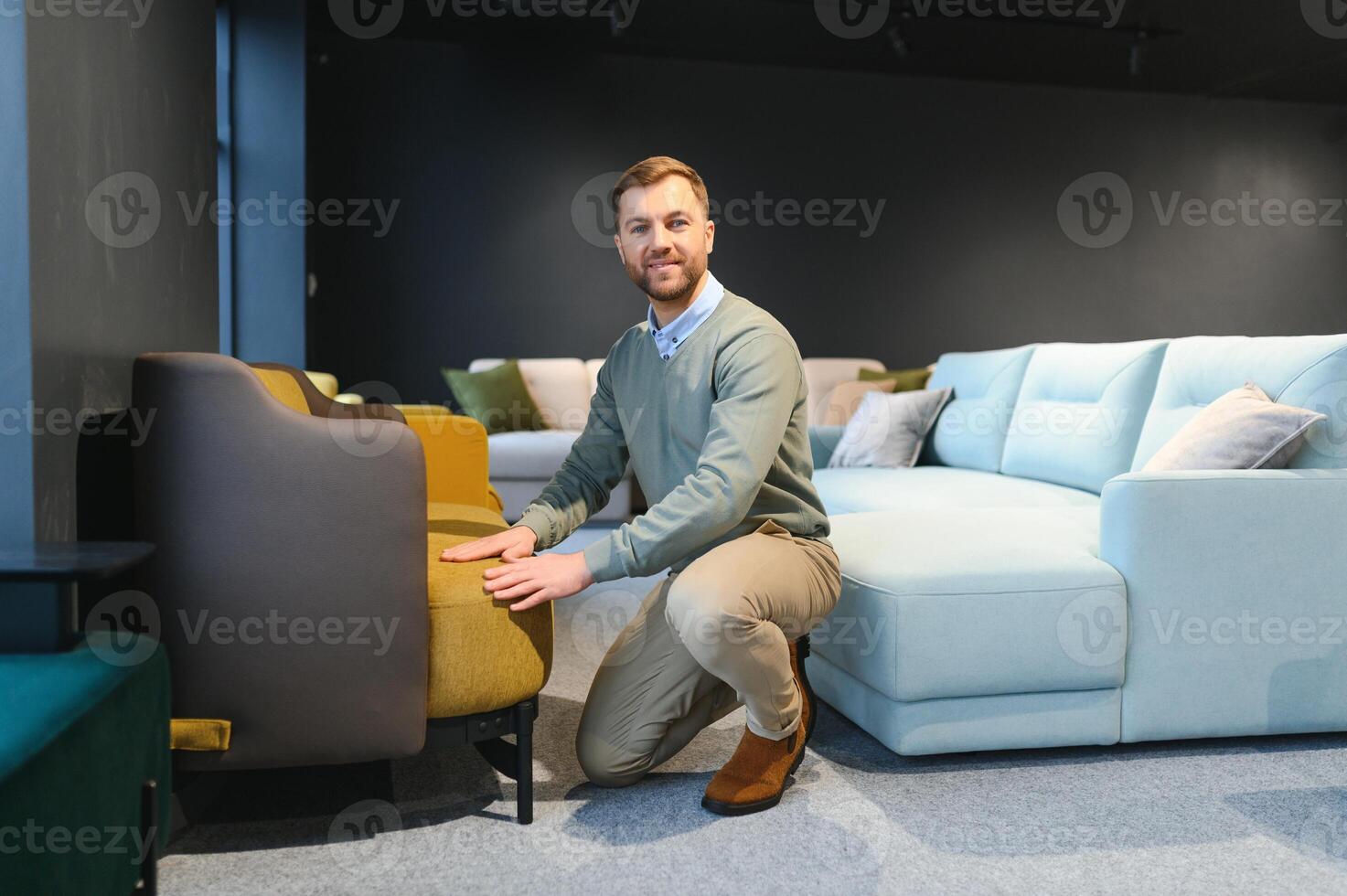 Young man buying sofa in furniture store photo