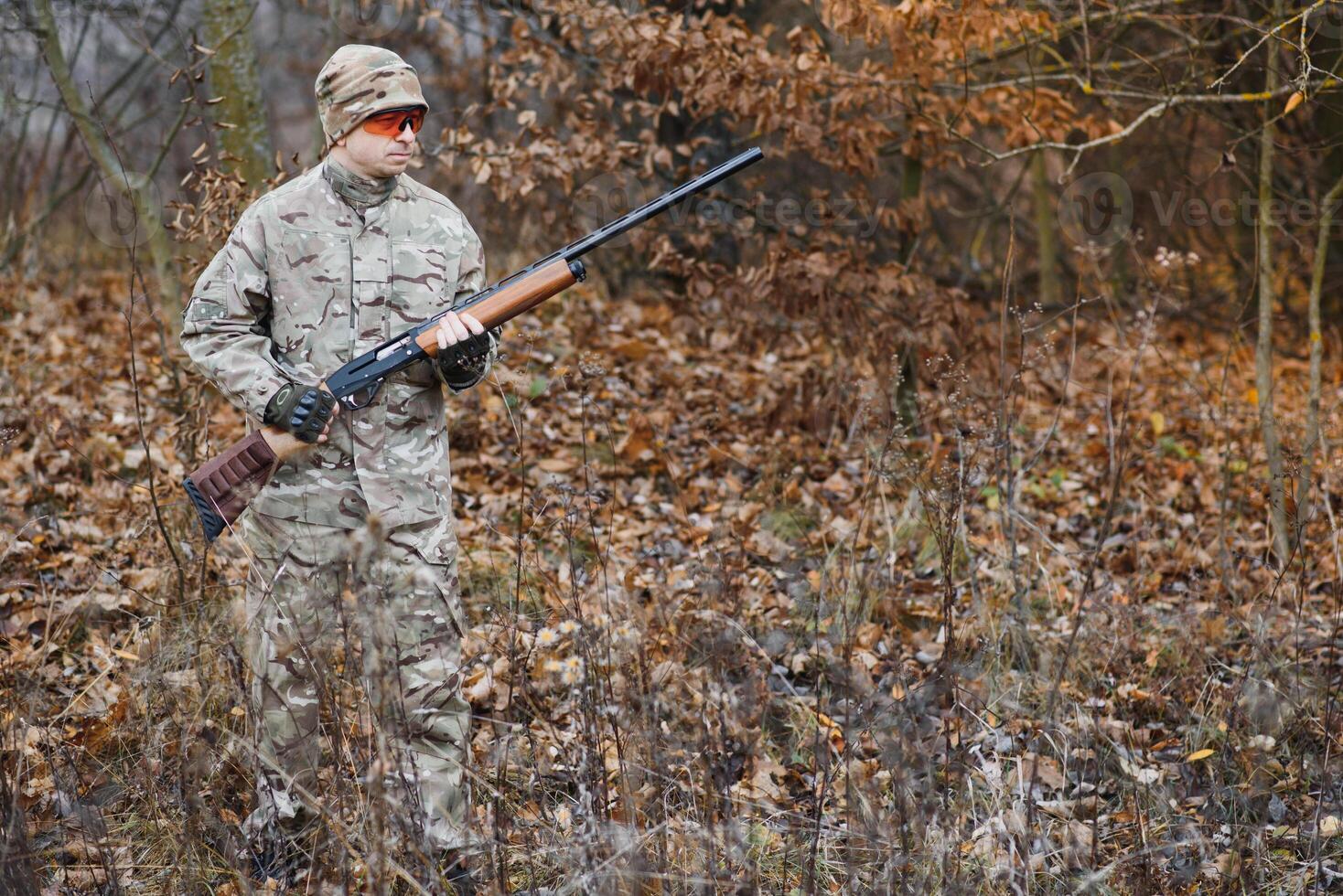 The hunter takes aim at the wild beast in the forest. Hunting concept photo