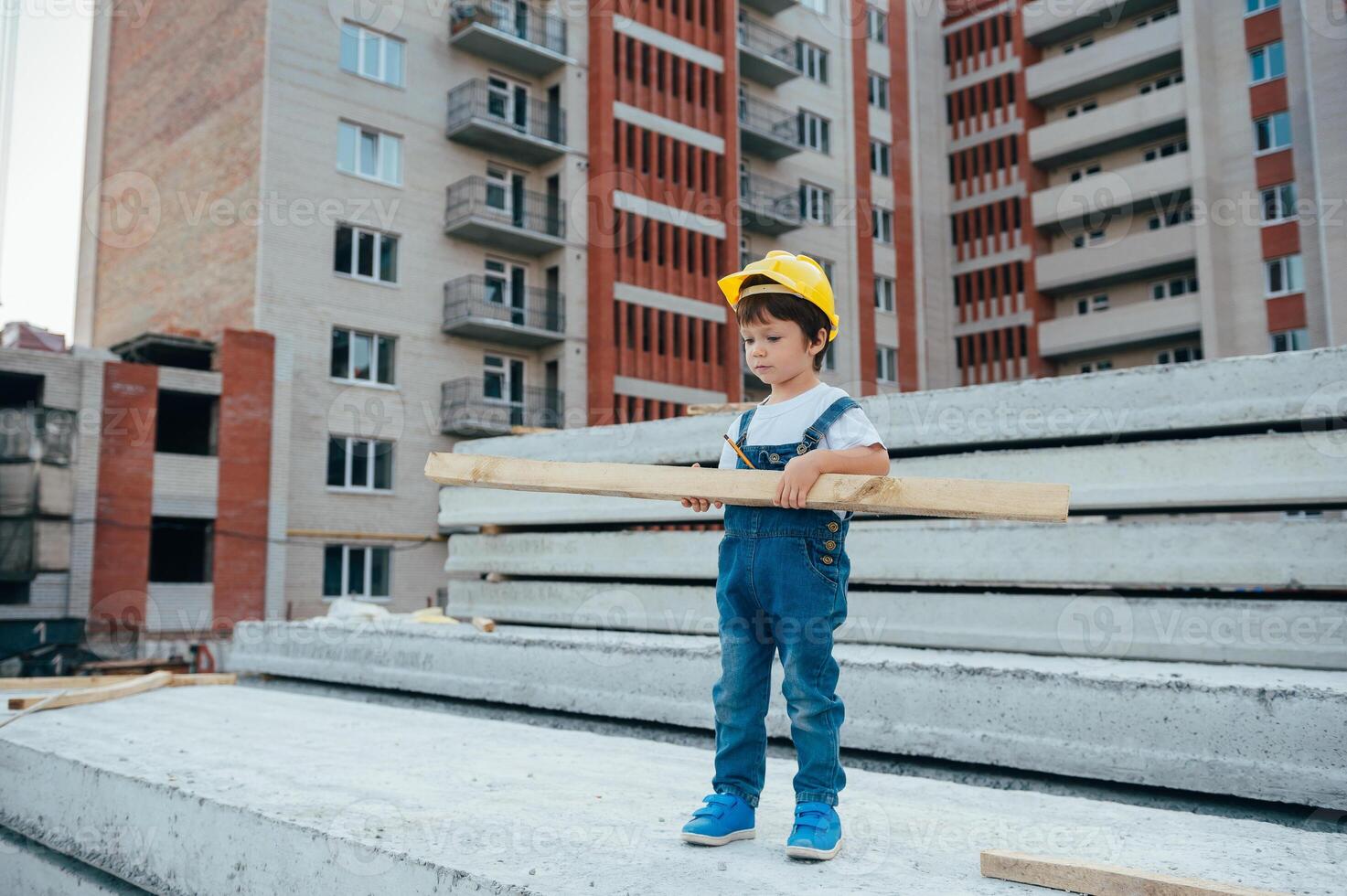 Architect in helmet writing something near new building. little cute boy on the building as an architect. photo