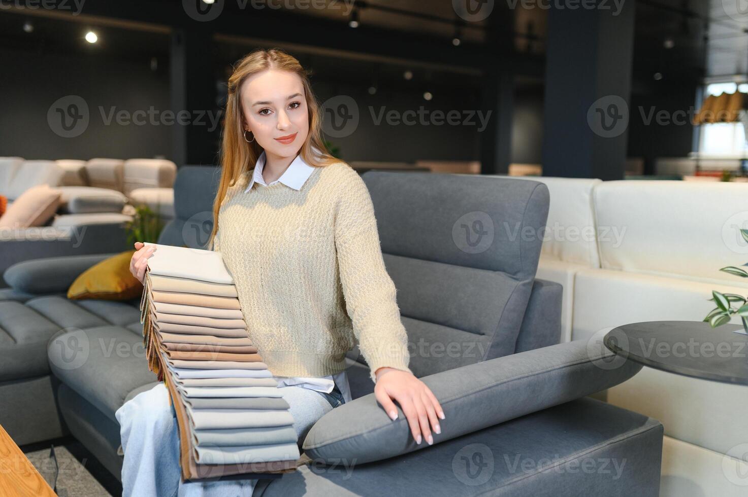 mujer diseñador a mueble Tienda mirando a textil muestra de tela foto