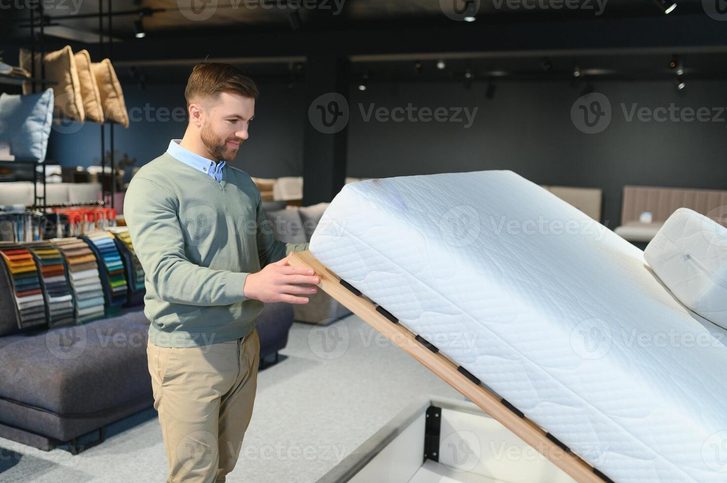 Man choosing orthopedic mattress in store photo