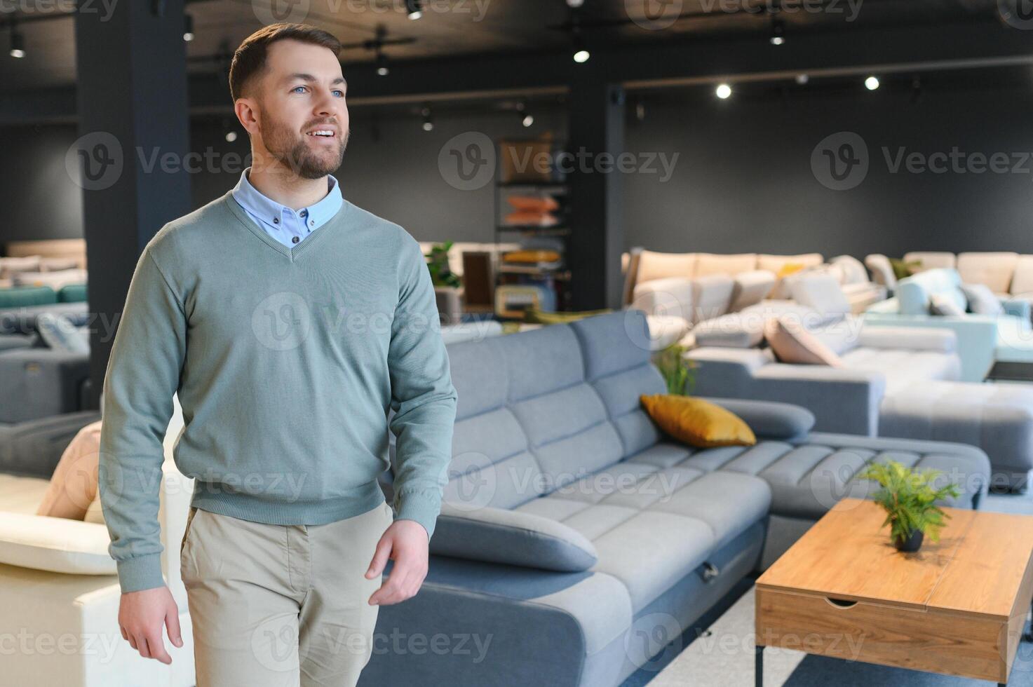 A handsome young man chooses furniture in a store photo