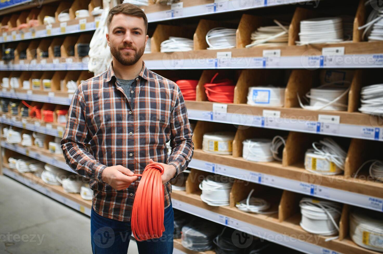 trabajador selecciona un eléctrico cable a un hardware Tienda foto