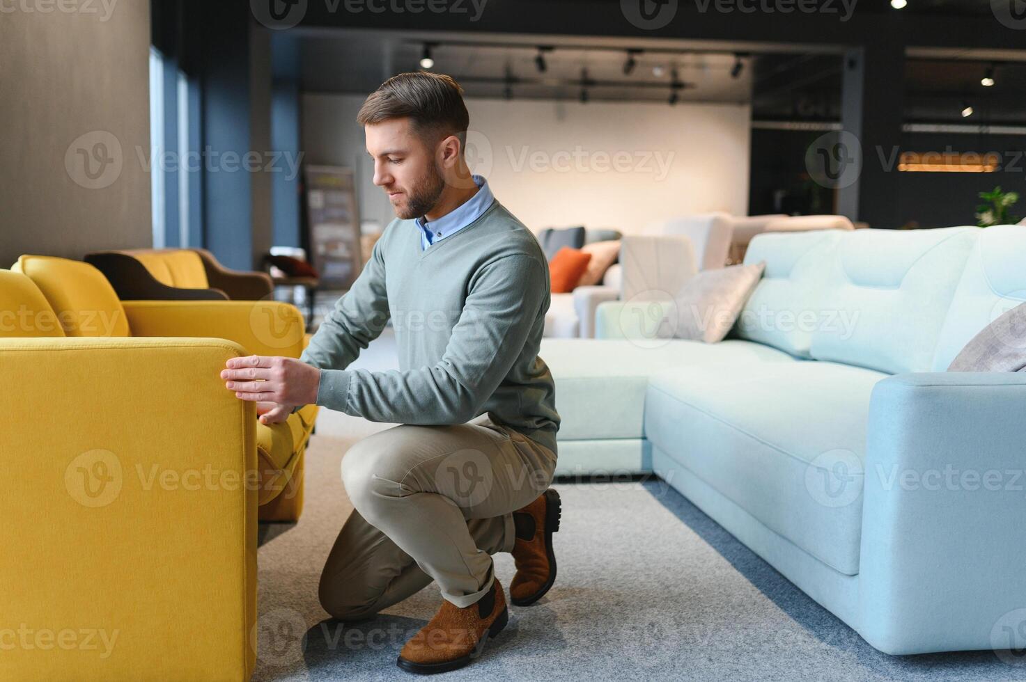 A handsome young man chooses furniture in a store photo