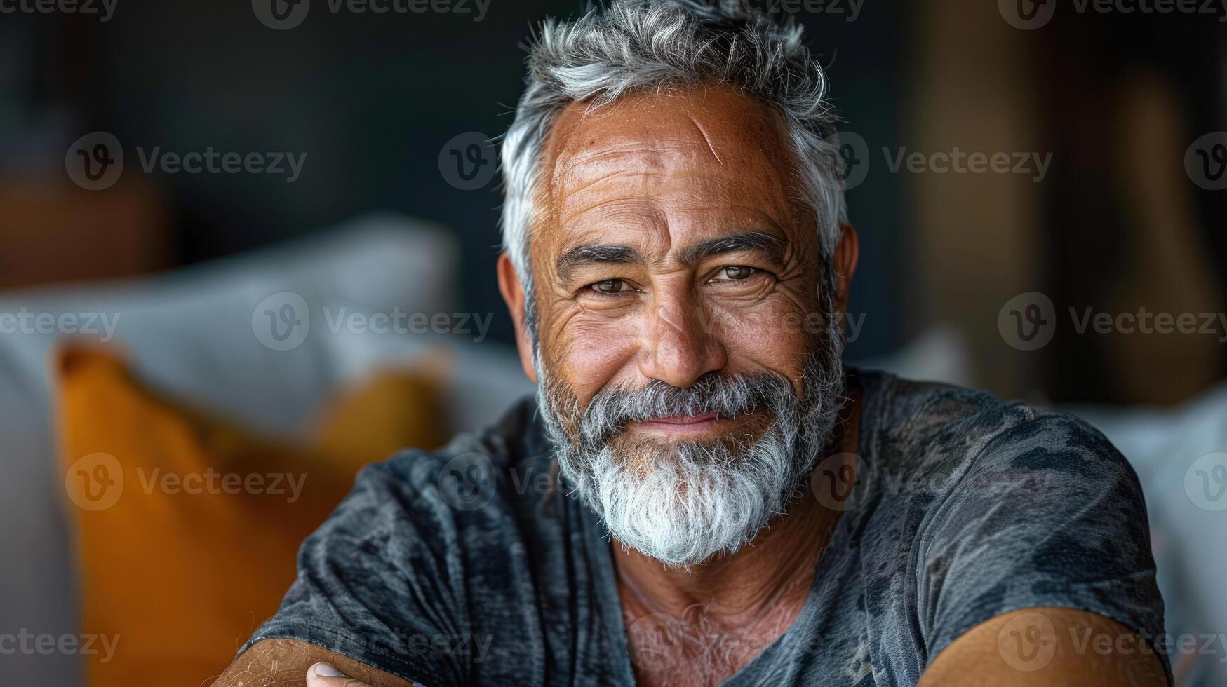 Elderly man with grey hair and beard sitting on beige couch photo