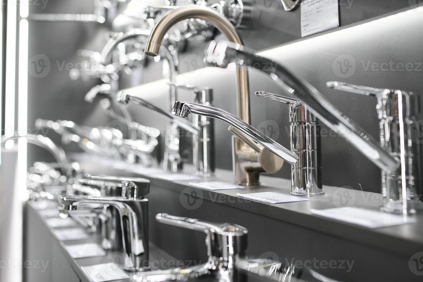 Water taps of different types and shapes on the counter in the store. Retail trade in sanitary ware. Foreground. photo