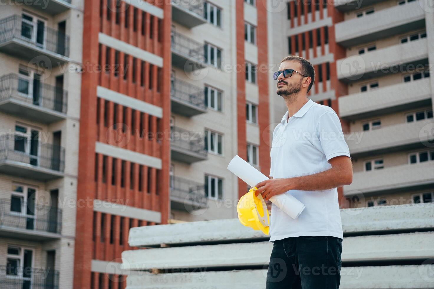 retrato de un arquitecto constructor estudiando diseño plan de el habitaciones, grave civil ingeniero trabajando con documentos en construcción sitio. foto