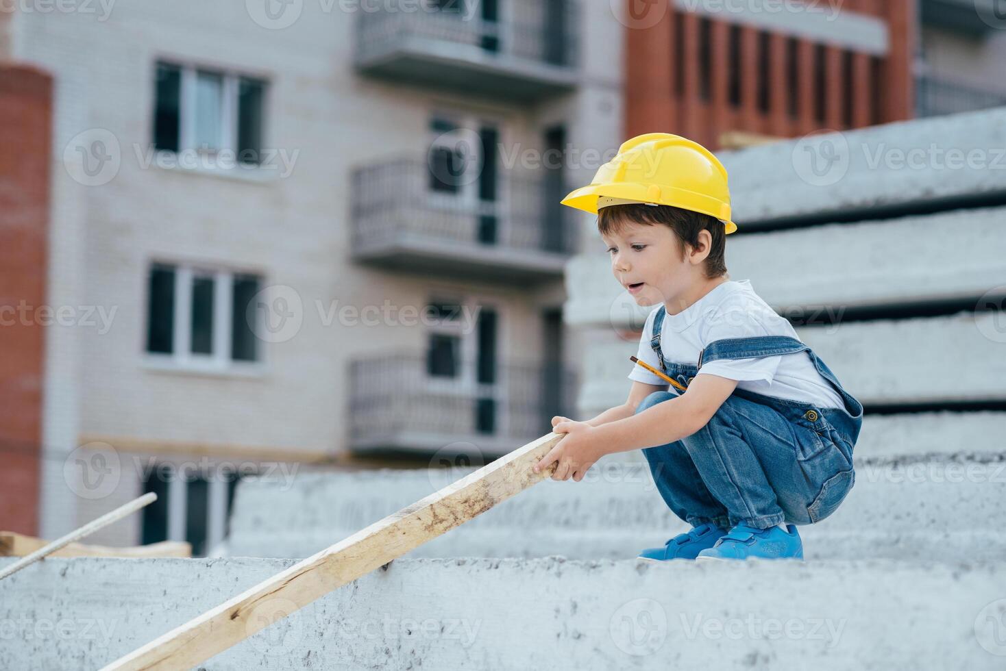 Architect in helmet writing something near new building. little cute boy on the building as an architect photo