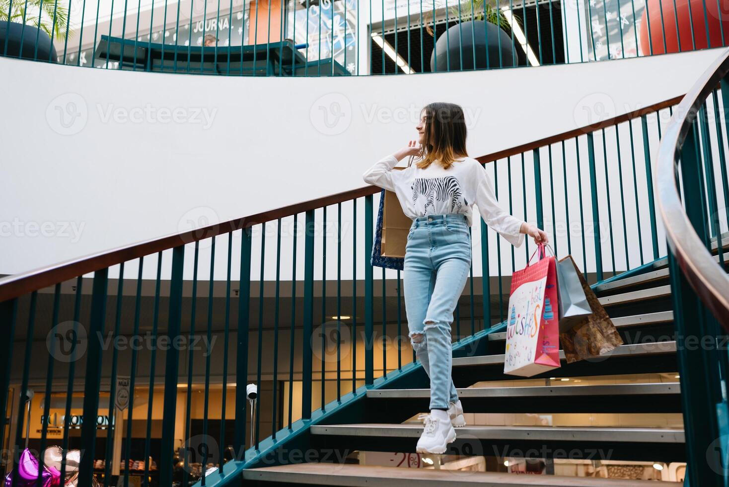 shopping, happiness and people concept - smiling stylish teenage girl with shopping bags. shopping concept. photo