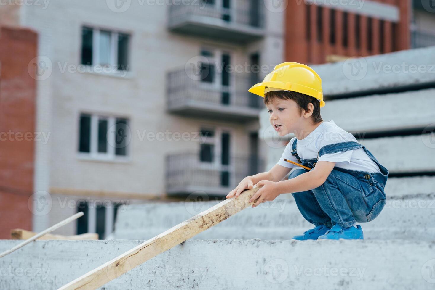 Architect in helmet writing something near new building. little cute boy on the building as an architect photo