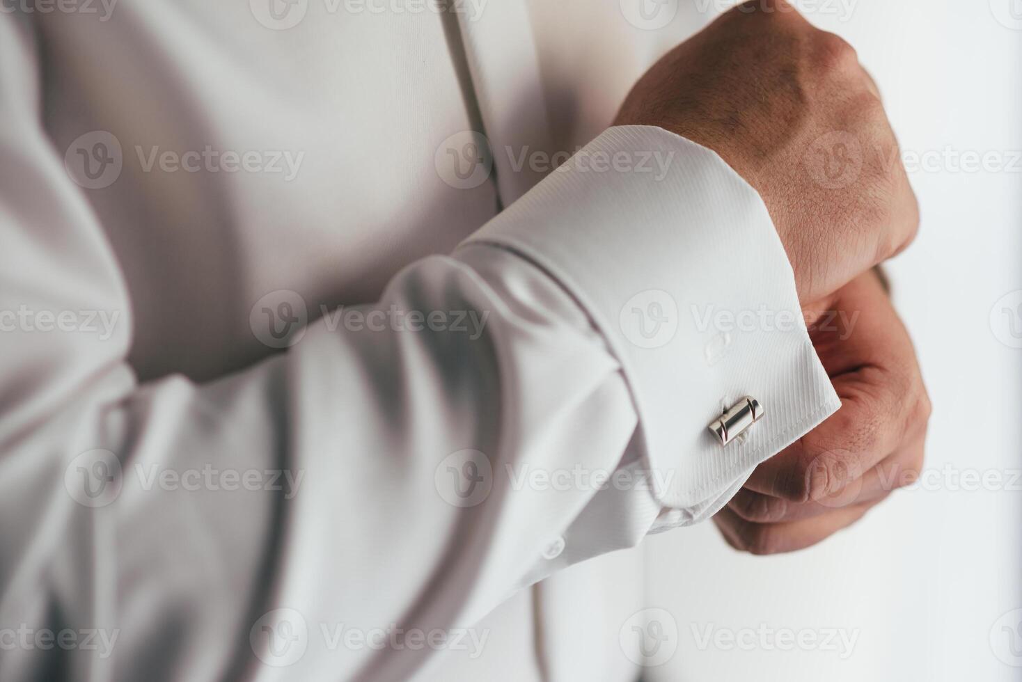 masculino manos en un antecedentes de un blanco camisa, manga camisa con gemelos y relojes, fotografiado de cerca. foto