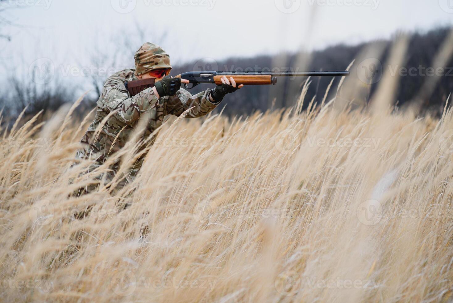 The hunter takes aim at the wild beast in the forest. Hunting concept photo