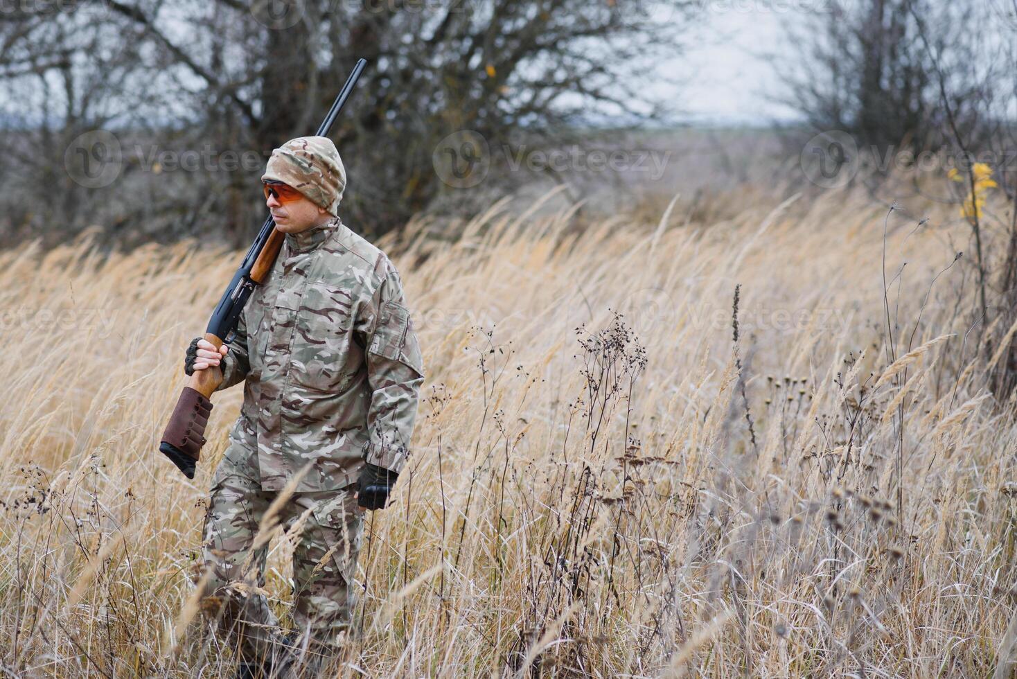 Hunter in uniform with a hunting rifle. Hunting Concept. photo