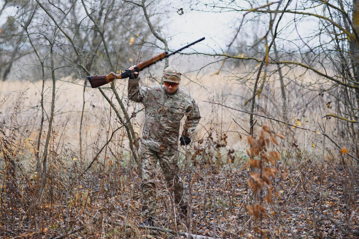 Hunter in uniform with a hunting rifle. Hunting Concept. photo