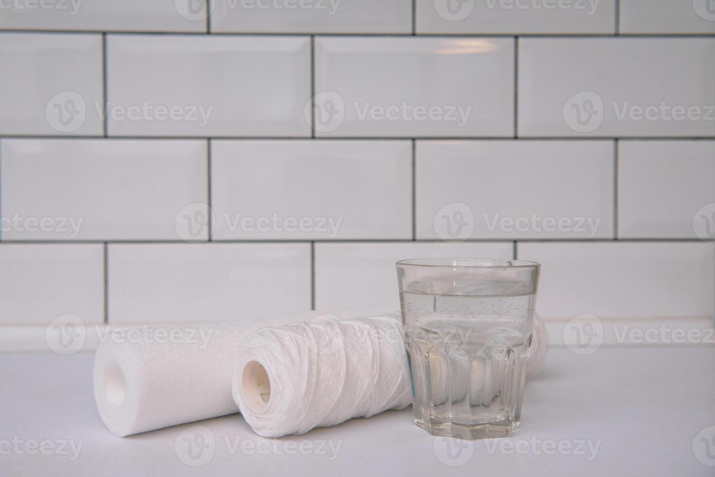 Water filters. Carbon cartridges and a glass on a white background. Household filtration system photo