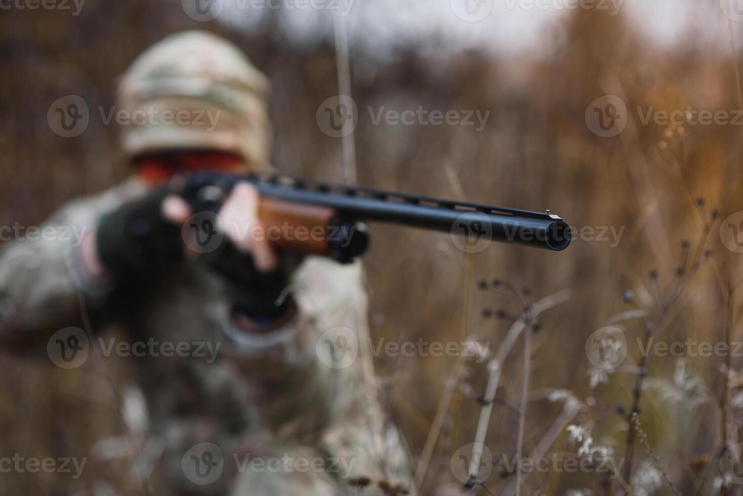 The hunter takes aim at the wild beast in the forest. Hunting concept. photo