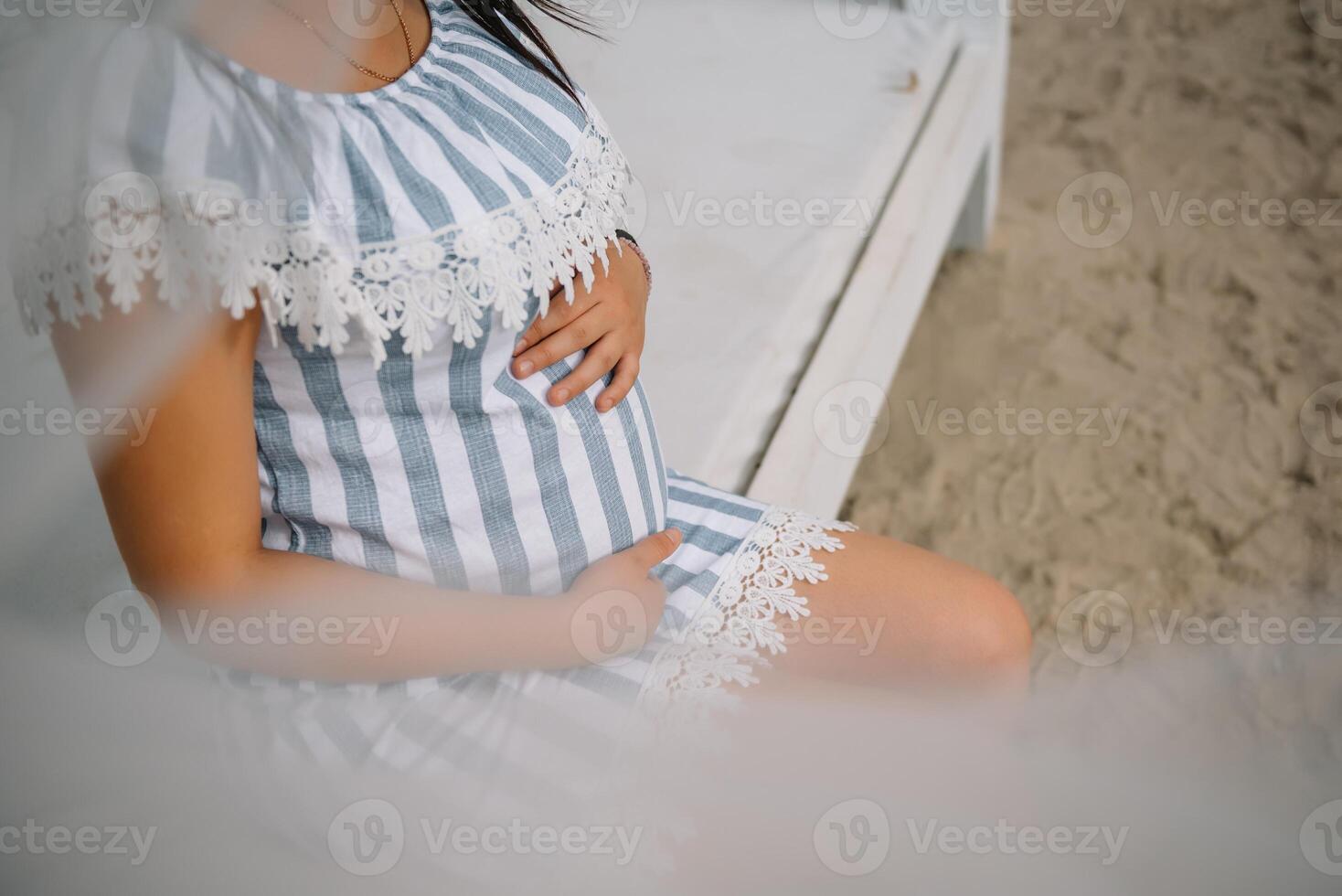 Beautiful pregnant woman holding belly outdoor. photo