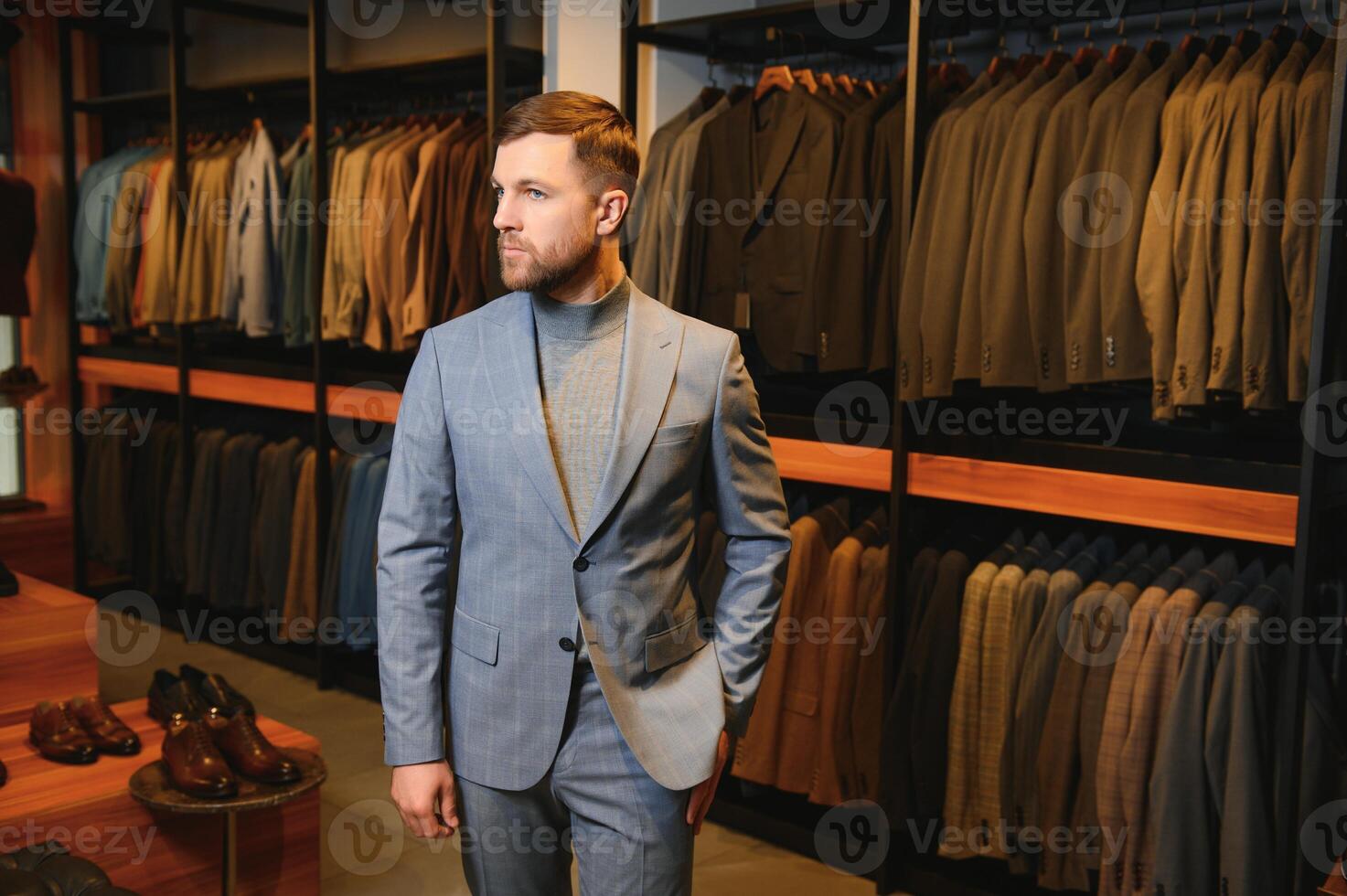 Modern young handsome businessman, looking and choosing classical suit in the suit shop photo