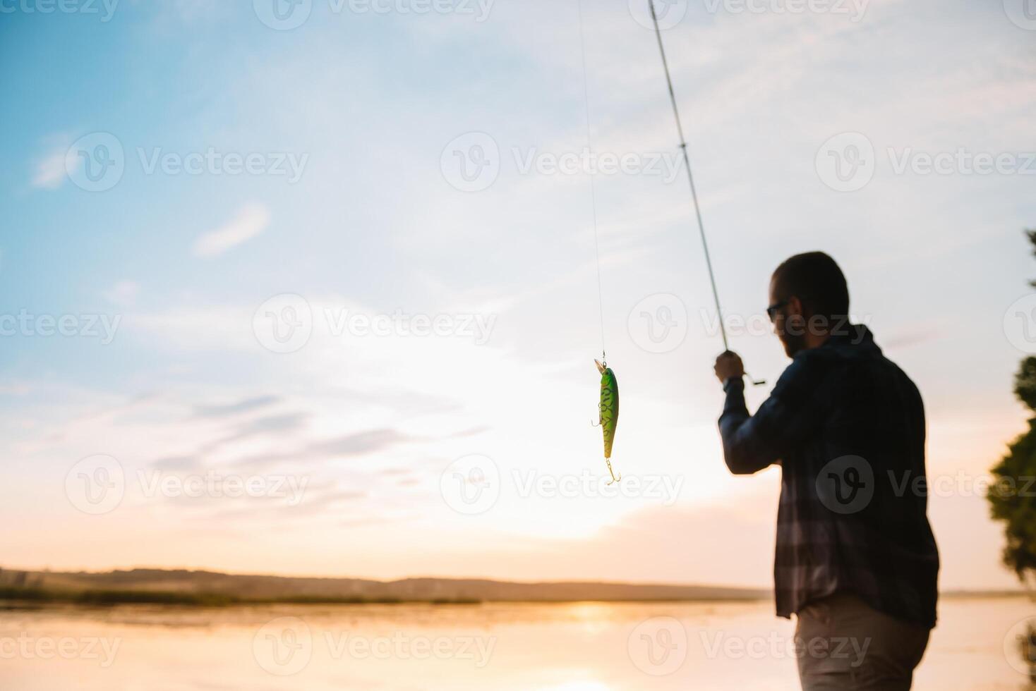 Fishing. spinning at sunset. Silhouette of a fisherman. photo