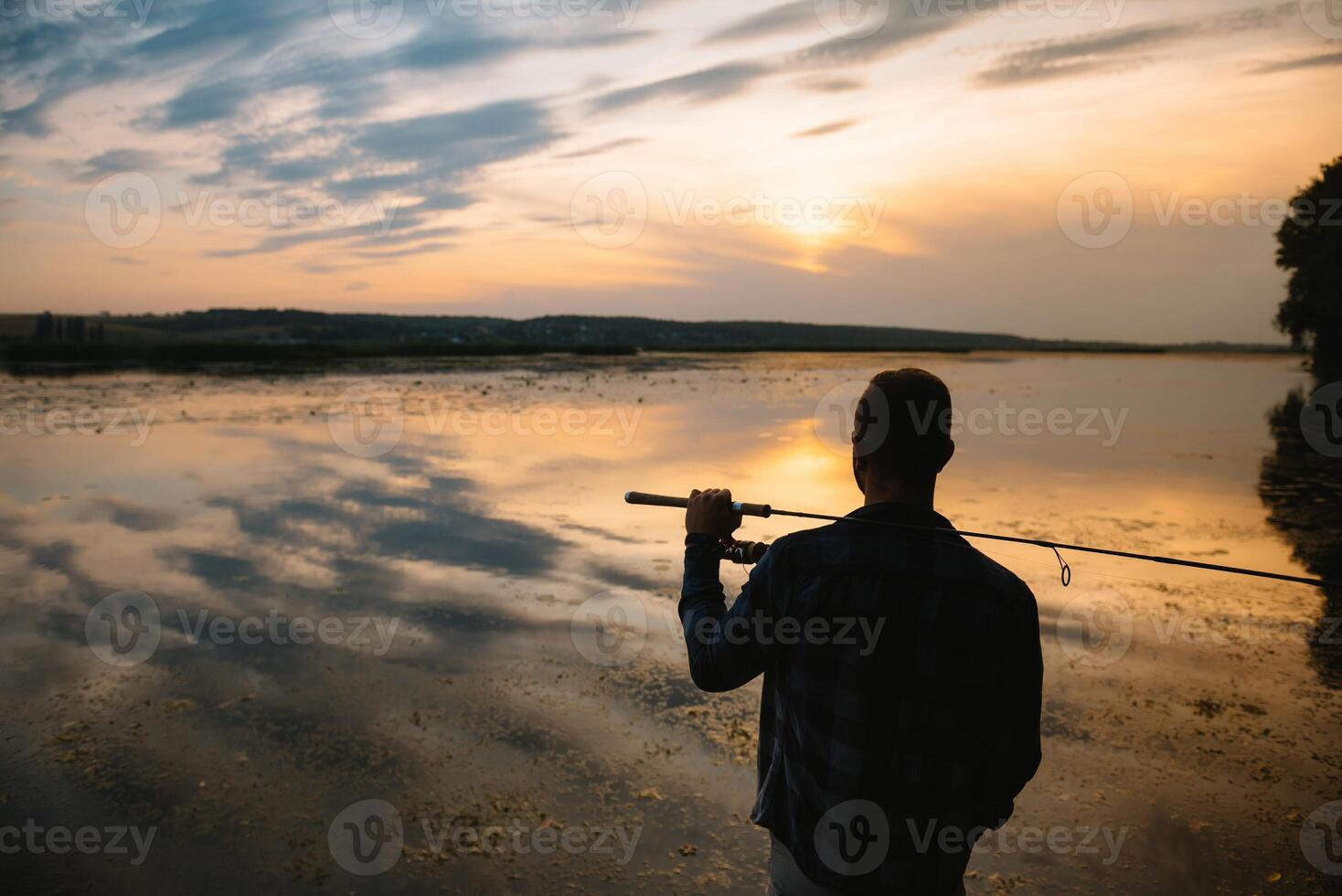 Fishing. spinning at sunset. Silhouette of a fisherman. photo