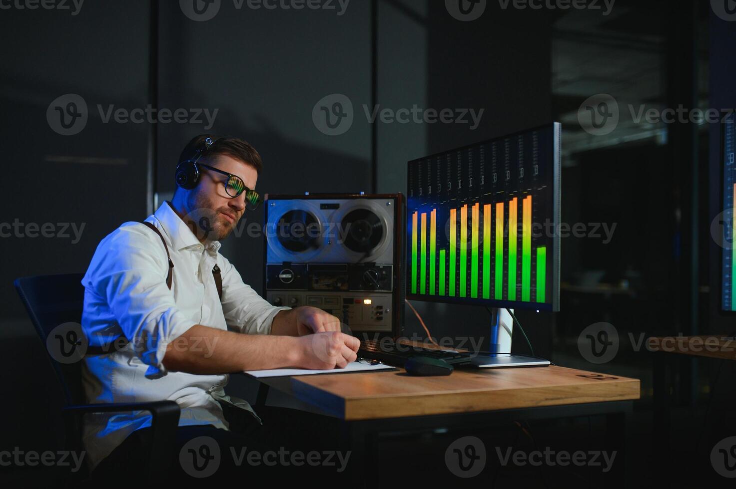 A male spy listens and records conversations on a reel-to-reel tape recorder photo