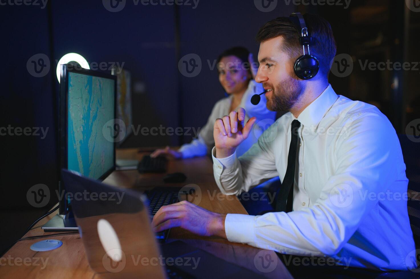 Center of dispatching maintenance. Portrait of cheerful woman and man working via headset microphone while sitting on navigation controller board photo