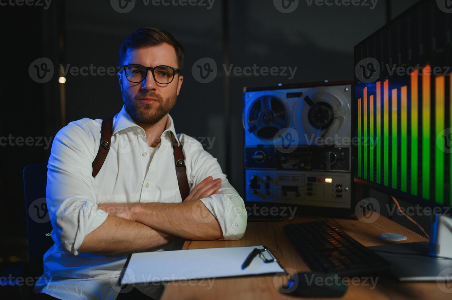 A male spy listens and records conversations on a reel-to-reel tape recorder photo