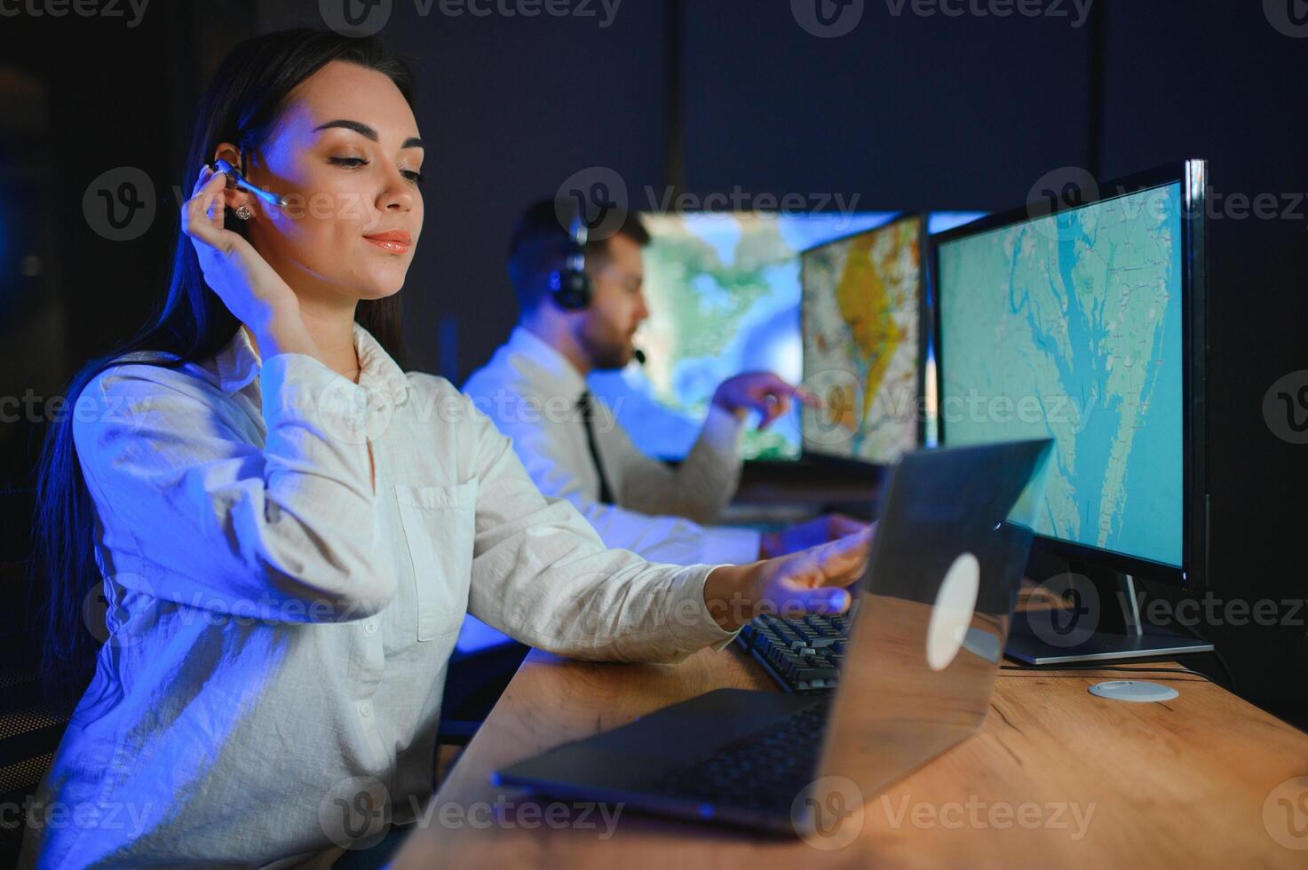 Smiling friendly female call center agent with headset working on support hotline in the office photo