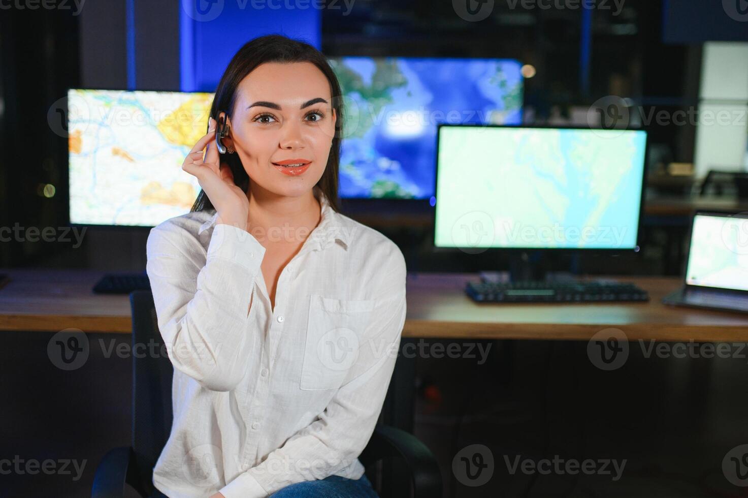 simpático sonriente mujer llamada centrar operador con auriculares utilizando computadora a oficina foto