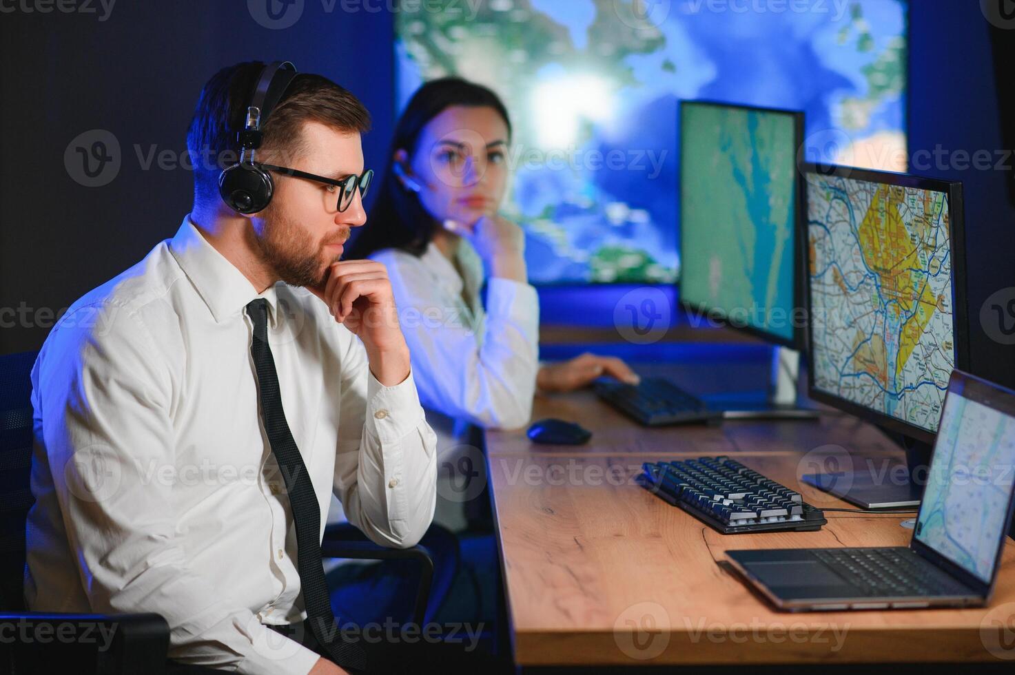 Center of dispatching maintenance. Portrait of cheerful woman and man working via headset microphone while sitting on navigation controller board photo