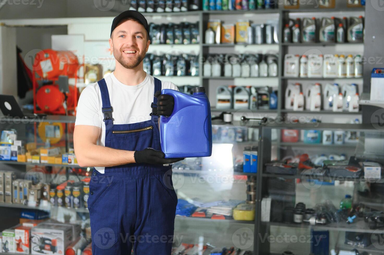 seller man with canister of motor oil in auto store photo