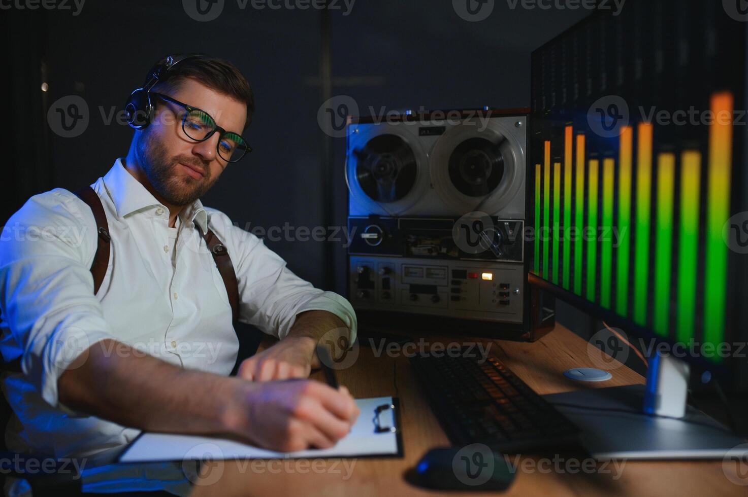 A male spy listens and records conversations on a reel-to-reel tape recorder photo