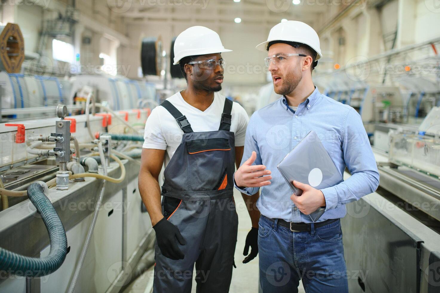 An engineer communicates with a worker on a production line photo