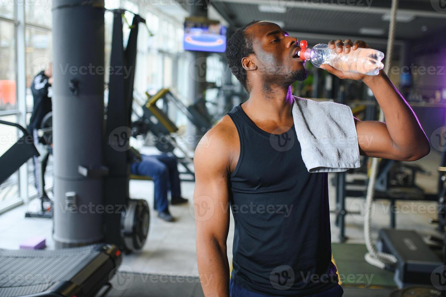 happy young african man drinking water after exercise photo