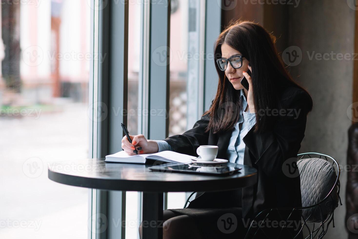 joven mujer de negocios hablando en el teléfono en café tienda foto