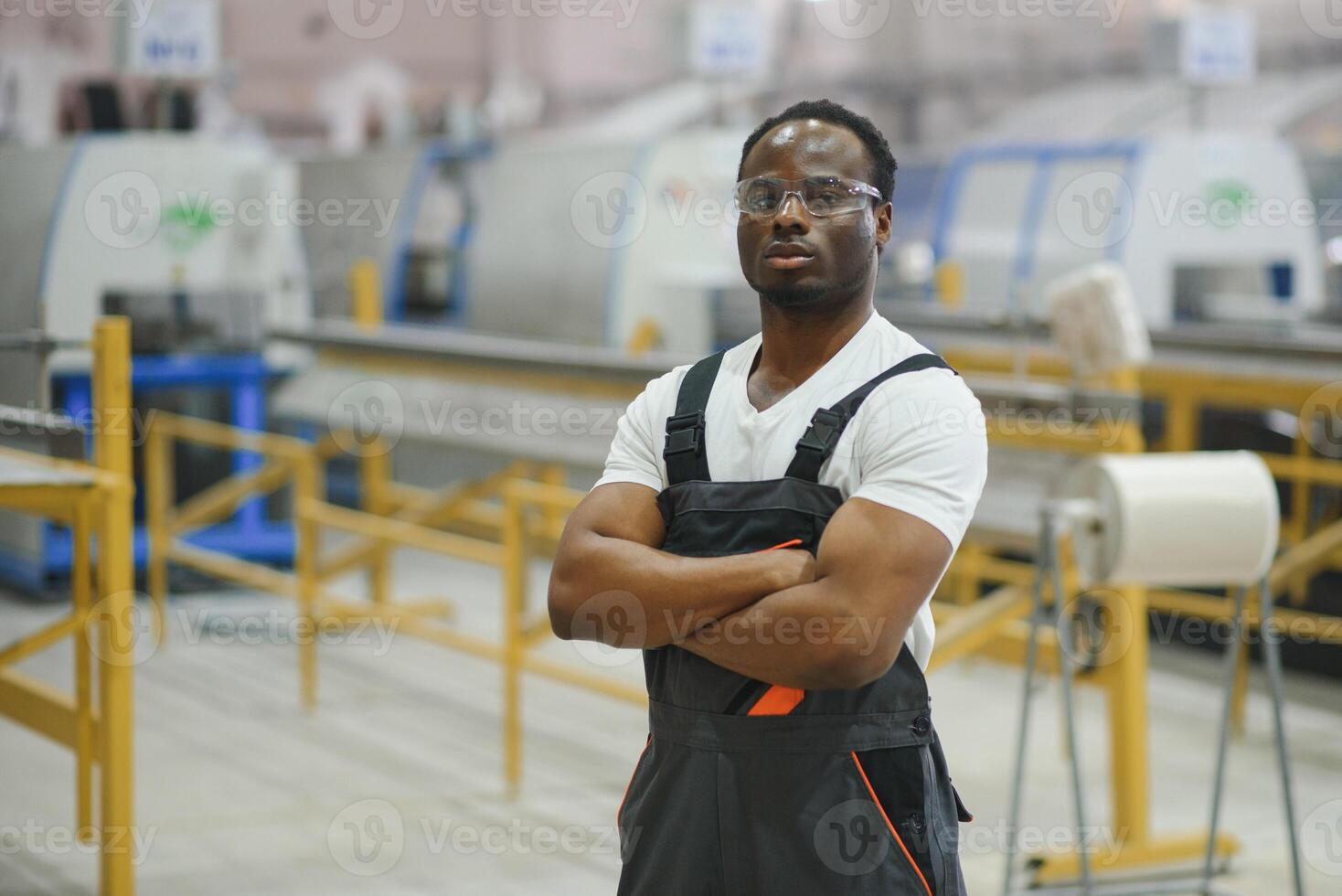 Professional Heavy Industry Engineer Worker Wearing Uniform, Glasses and Hard Hat in a Factory photo