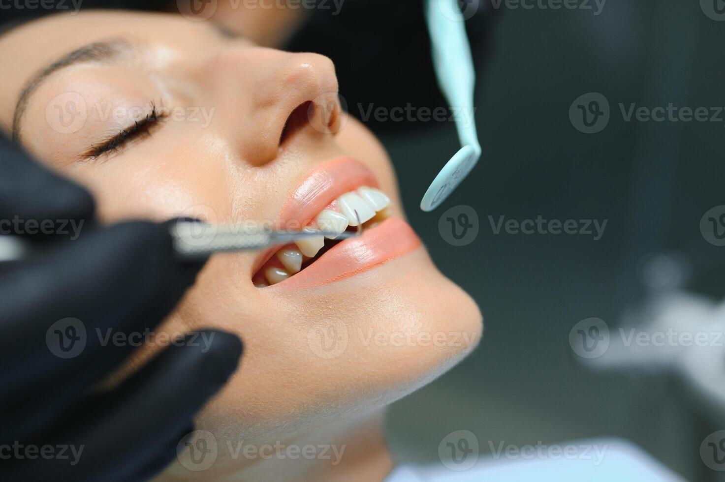 Dentist examining patient's teeth, close up photo