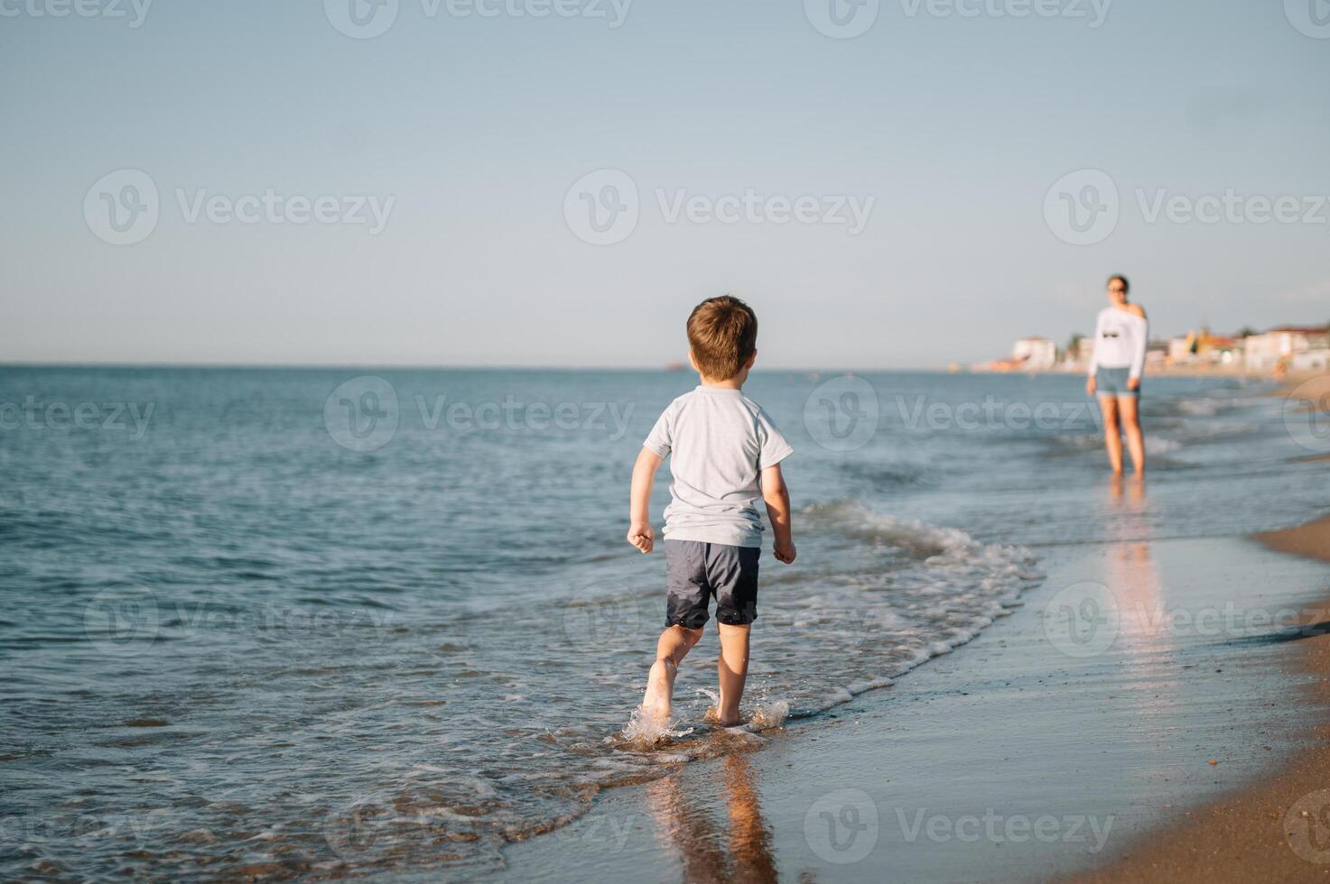 linda pequeño chico corriendo en playa y tener divertida. foto