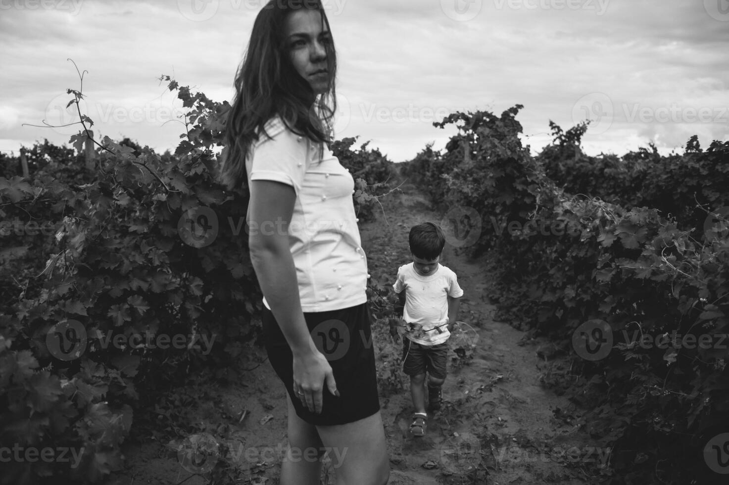 hermosa joven sonriente familia chico y madre teniendo divertido a un viñedo foto